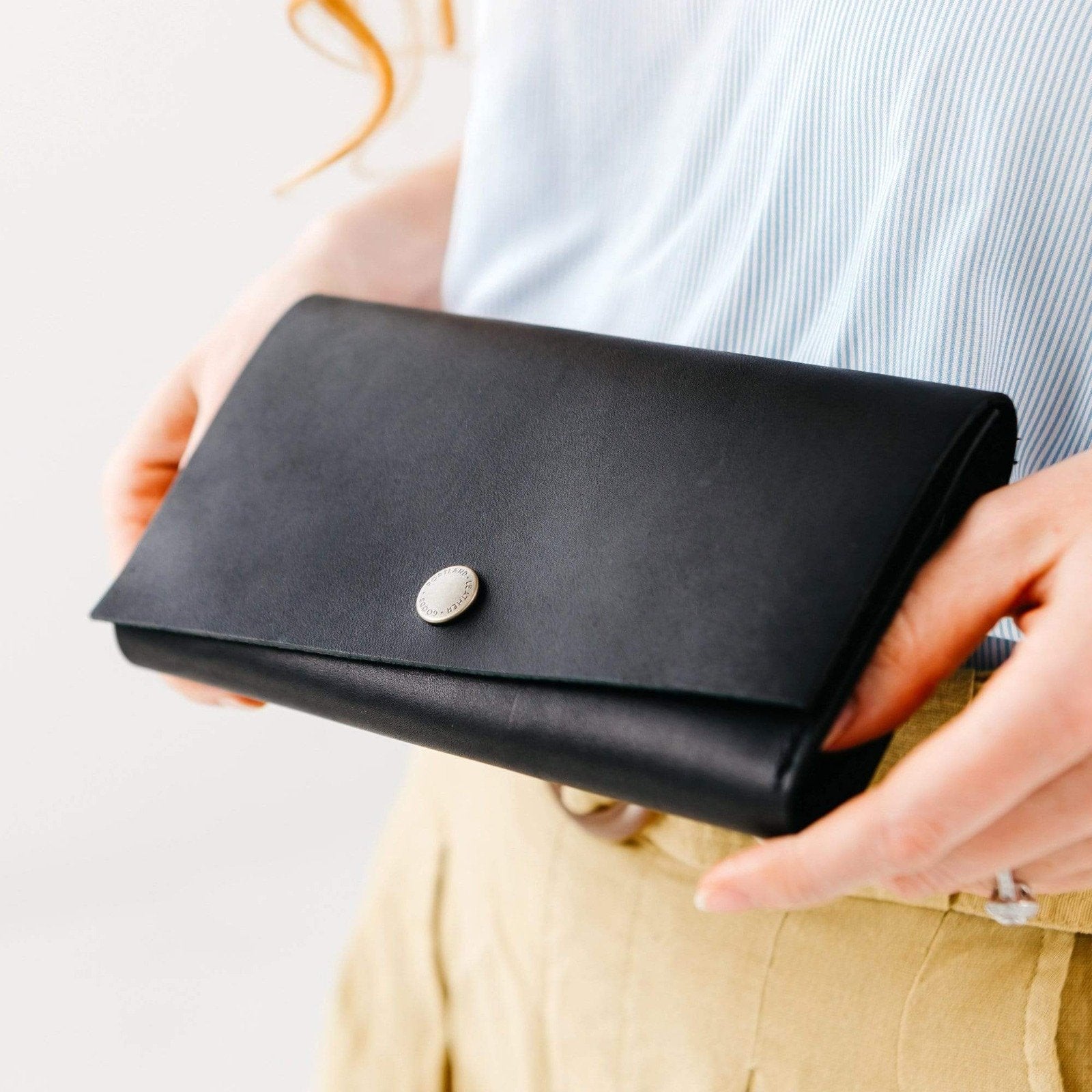 Black | Model holding leather wallet with snap closure