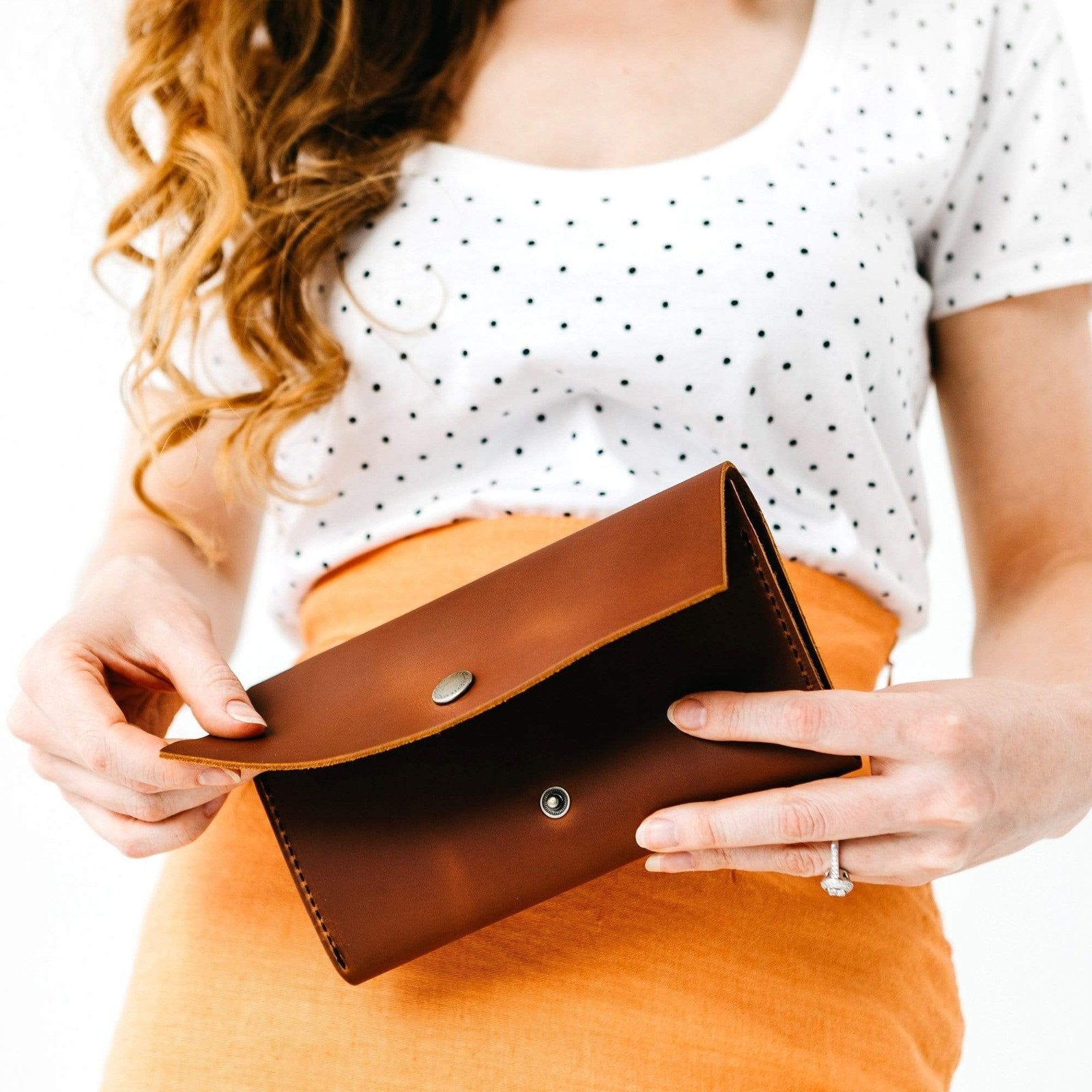 Honey | Model holding leather wallet with snap closure slightly open