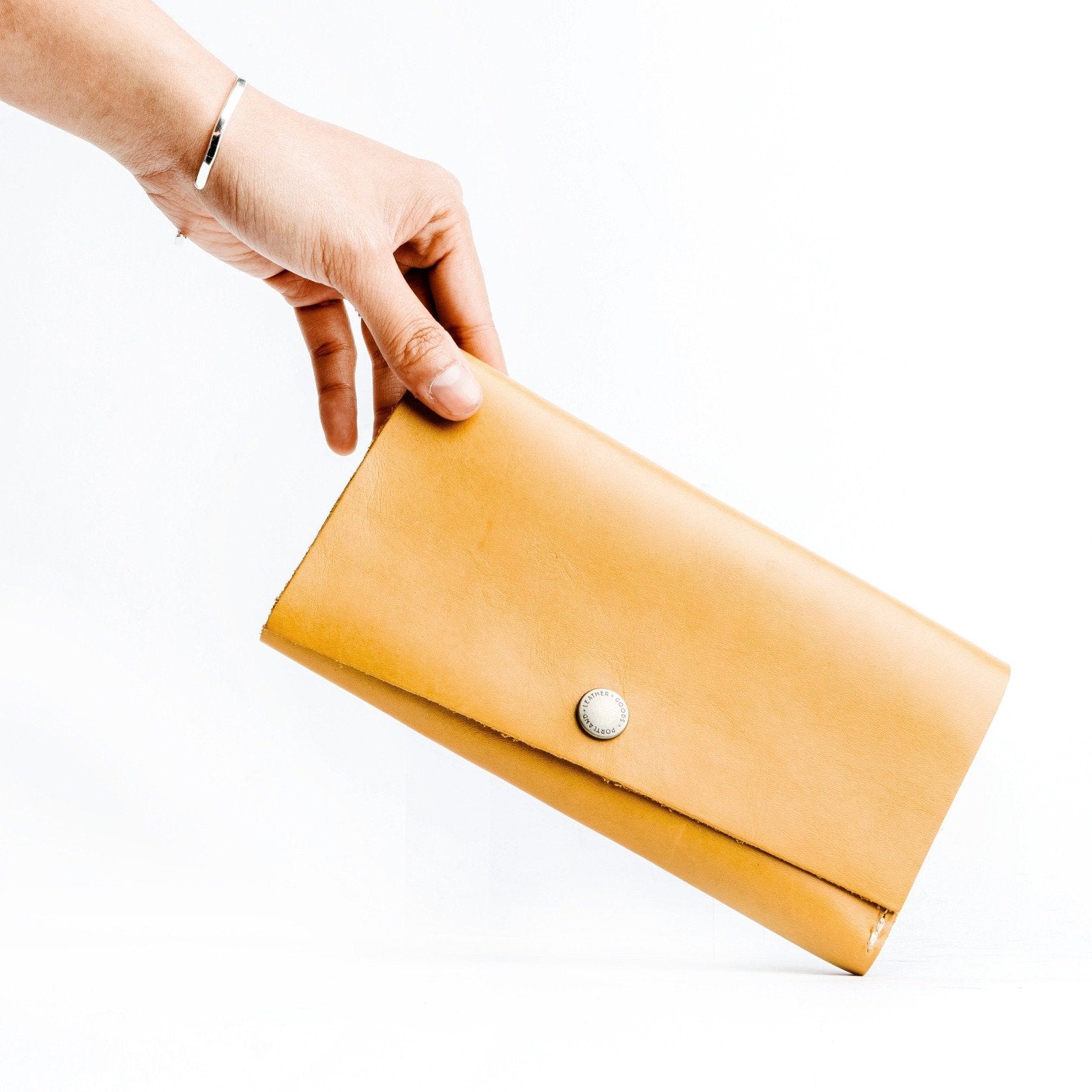 Sunflower  | Model holding leather wallet with snap closure