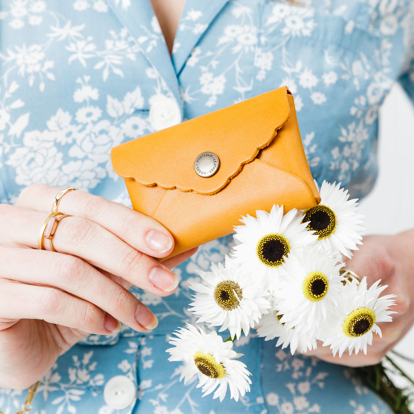 Sunflower | Model holding flowers and small leather wallet with scalloped edge