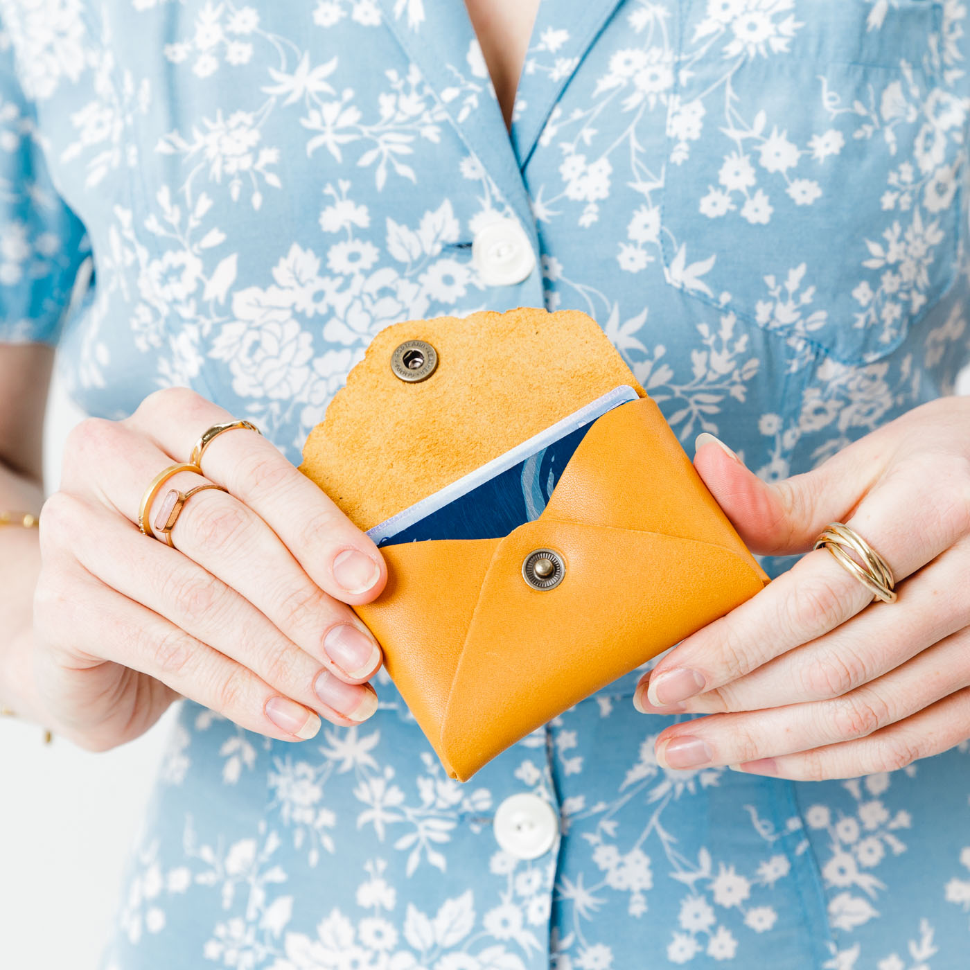 Sunflower | Model holding small leather wallet with scalloped edge open